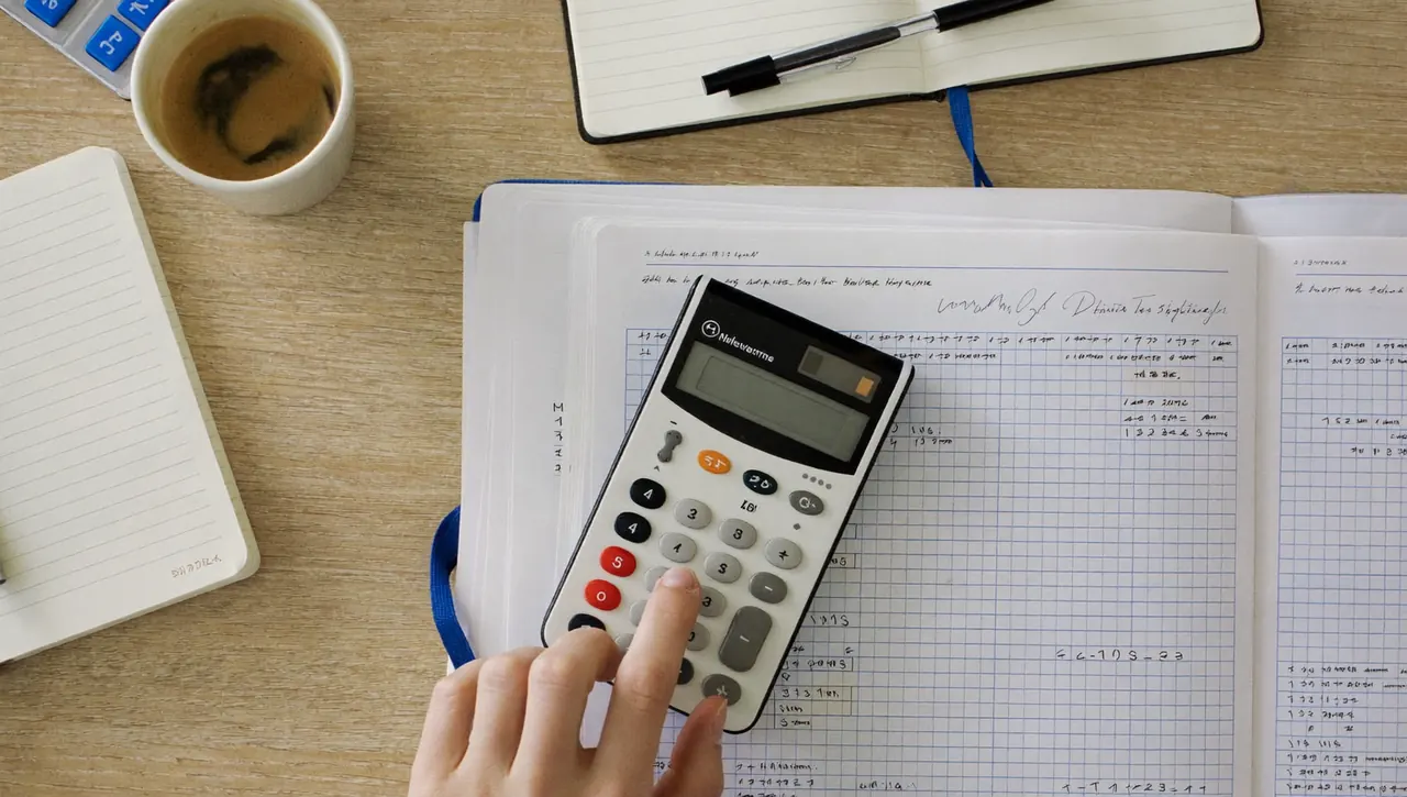 Finance paperwork and a calculator on a desk for spreading window costs